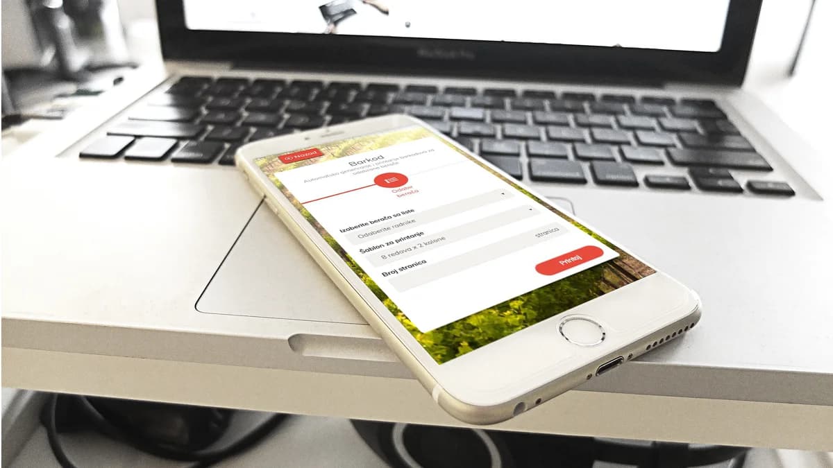 A phone lying on a laptop keyboard, showing the META5 app's barcode screen: picker selection, print template and a Printaj button, with a vineyard in the background